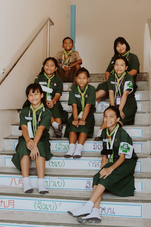 Smiling Students Sitting on Concrete Staircase 