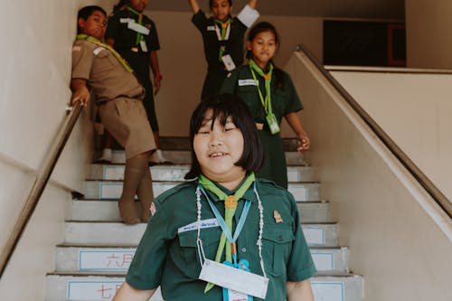 Free Girls in Green Uniform Walking Down the Stairs Stock Photo