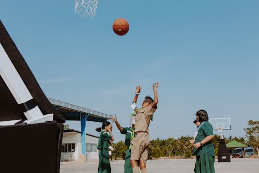 Children enjoying a game of basketball outdoors, showcasing vitality and teamwork.