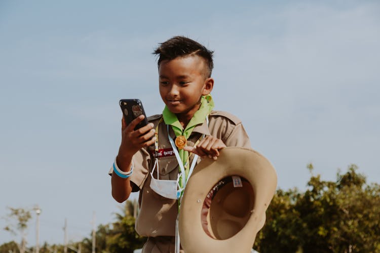 Boy Scout Looking At Smart Phone