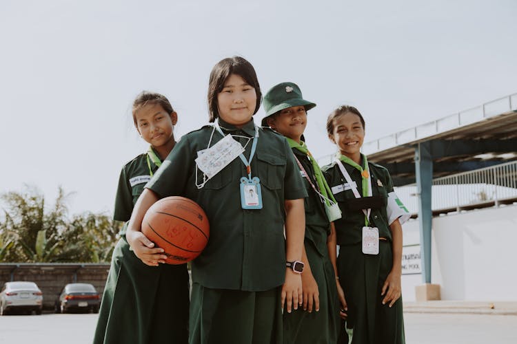 A Group Of Students Standing On A Basketball Court