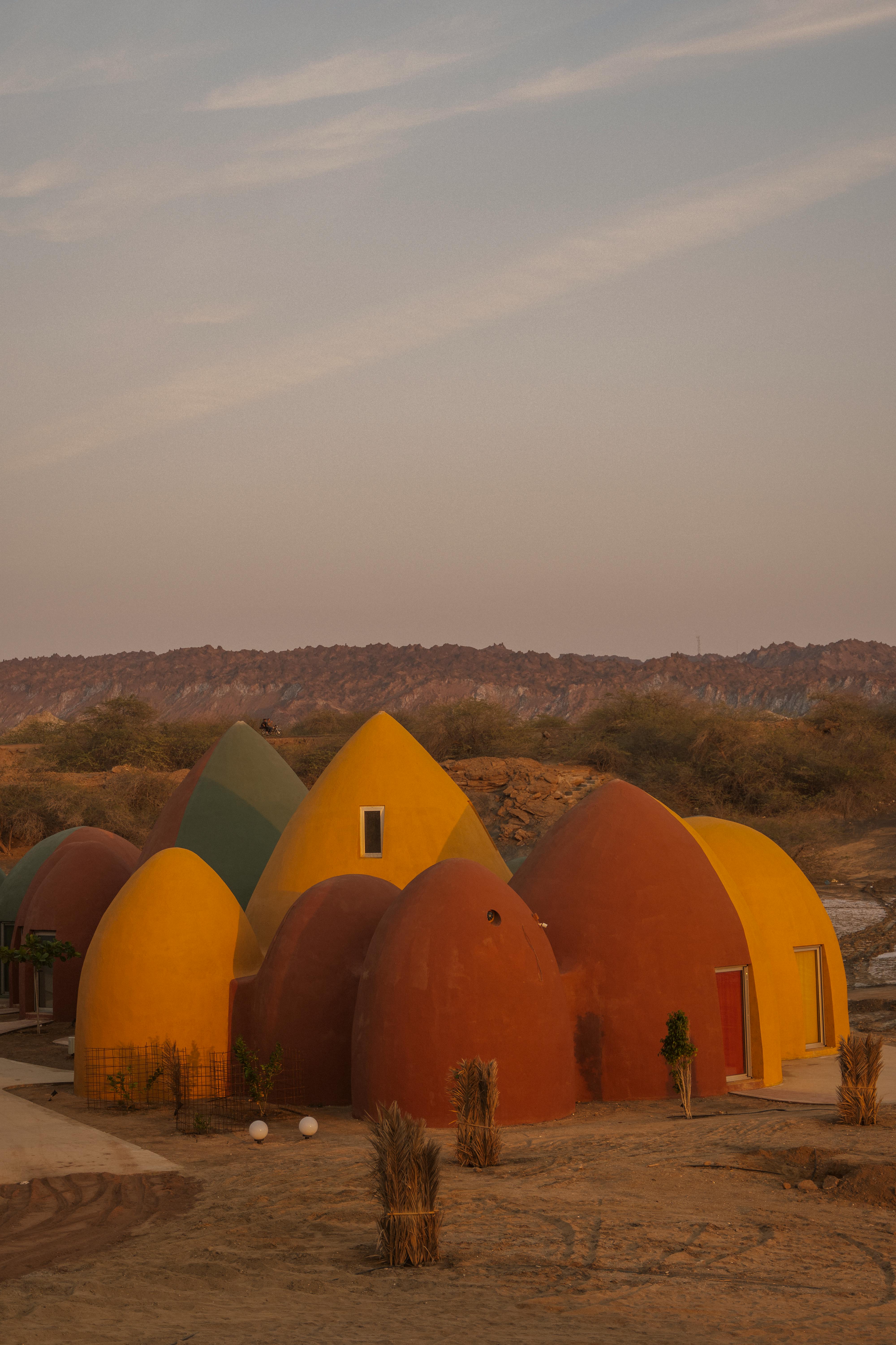 Vibrant dome-style architecture in desert setting, captured at sunset with warm tones.