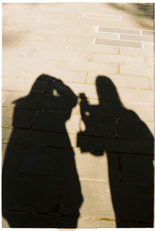 Free Shadow of two people on a sunlit pavement creating an intriguing silhouette effect. Stock Photo