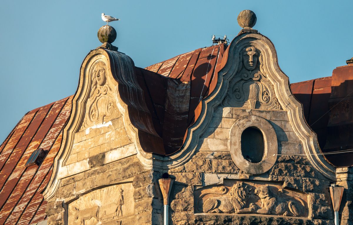 Fronton Art Nouveau cu chipuri sculptate pe o clădire din Riga