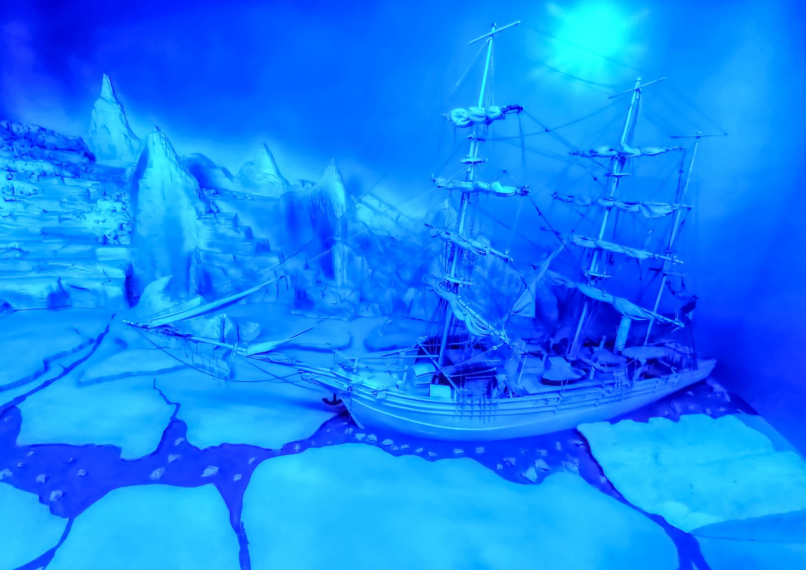 Maquette de voilier prise dans la banquise sous une lumière bleue