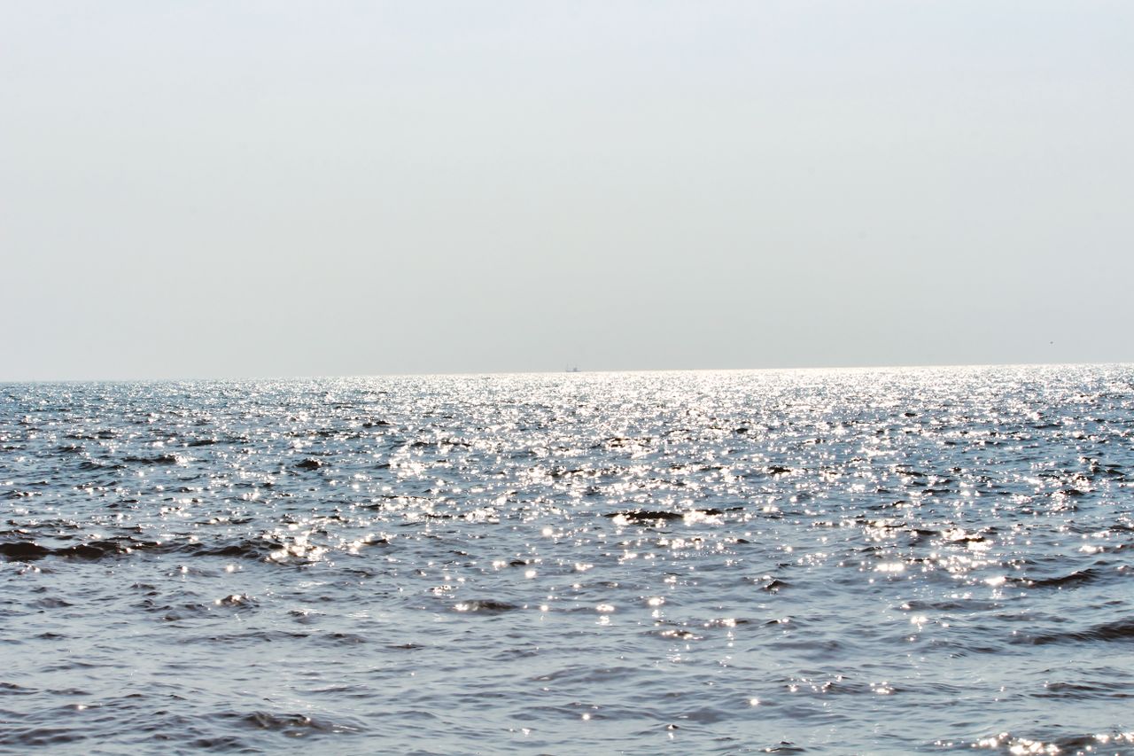 a peaceful ocean view with sparkling sunlight on the water and a clear