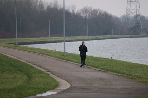 A Woman Running Near Body of Water