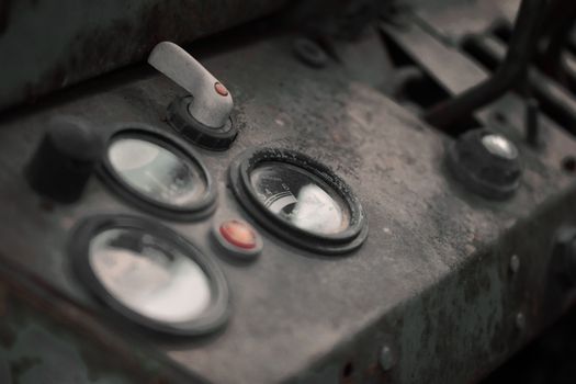 Close-up of an old, dusty control dashboard in a vintage vehicle.