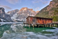 一座宁静的湖边小屋倒映在群山环绕的水面上