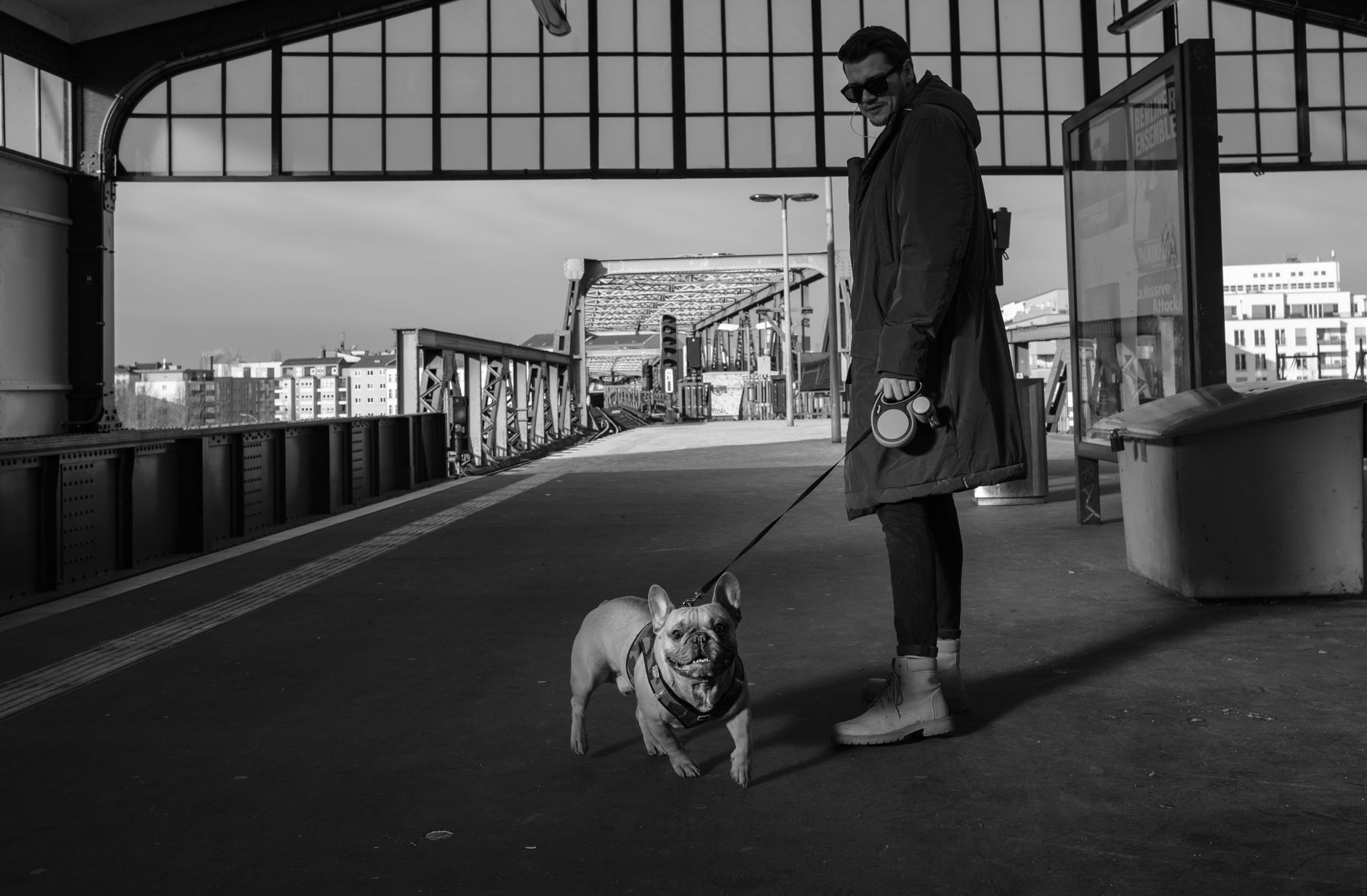 Person walking a dog on a leash through a busy train station