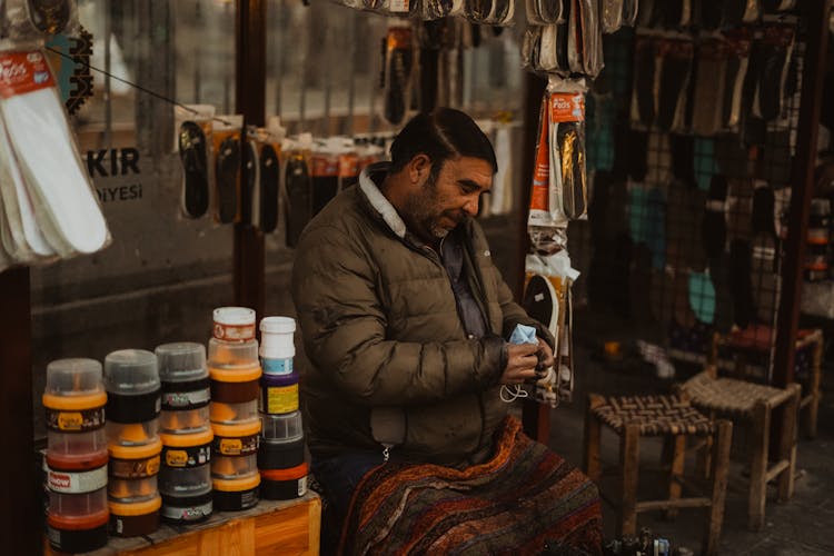 A Shoeshiner Wearing A Puffer Jacket