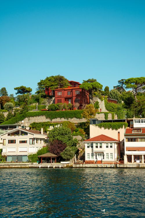 Free Beautiful waterfront homes with lush gardens under a clear sky. Stock Photo