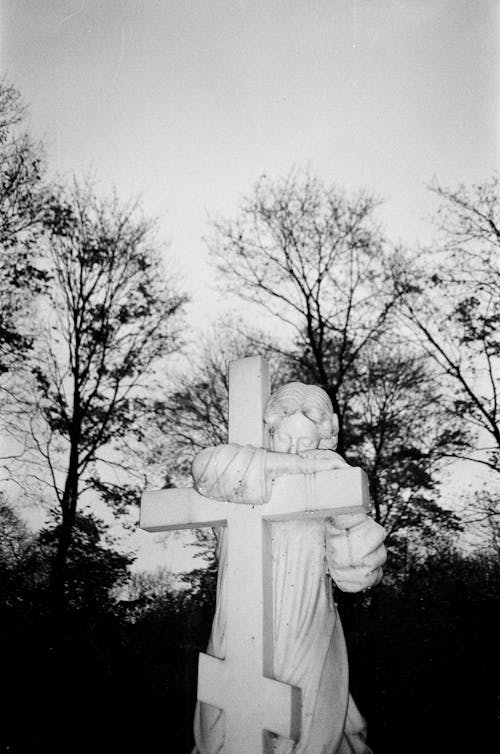 Free Statue of Angel with Cross on Graveyard, Black and White Stock Photo