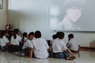 Children in School Uniforms Watching Movie in Classroom