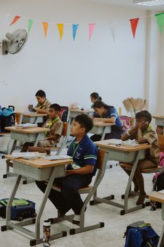 Children focusing on a lesson in a well-organized classroom setting.
