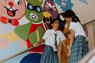 Girls in School Uniforms Laughing in School Staircase