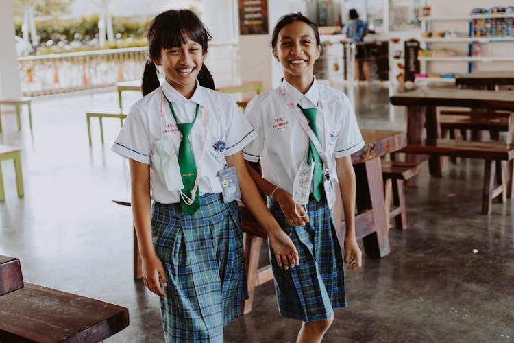 Two Girls In School Uniform Smiling While Walking