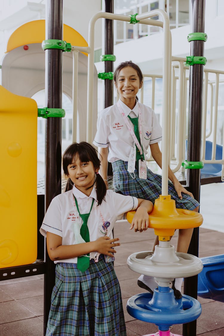 Girls In School Uniform Sitting On The Playground