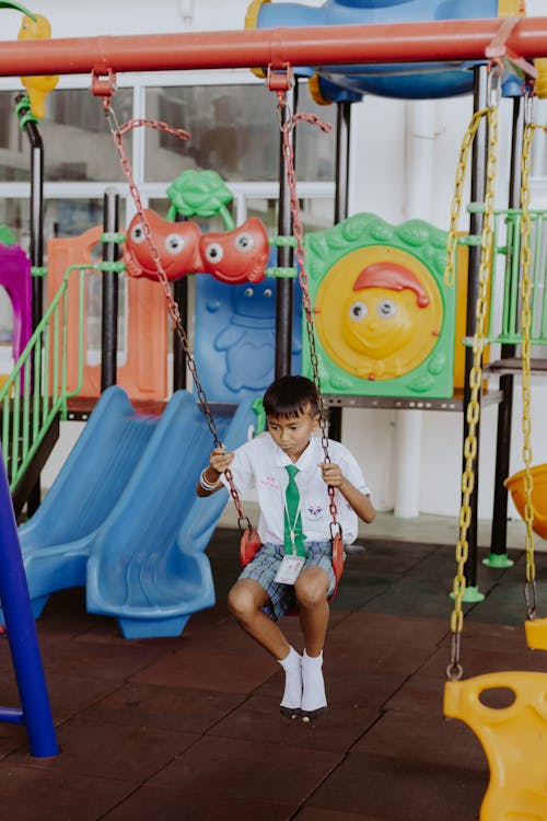 Boy in School Uniform Swinging in School Gymnasium