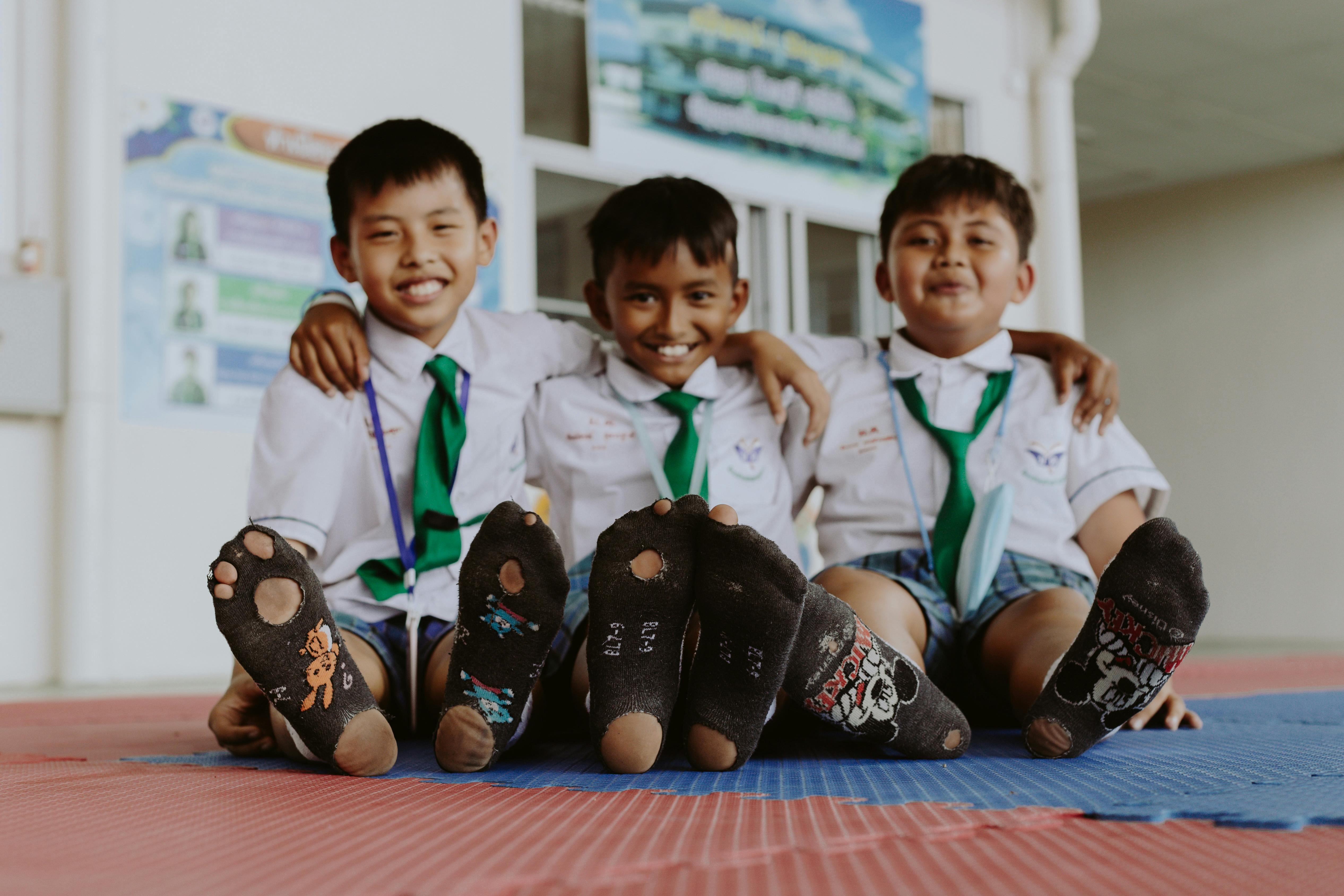 Portrait of Smiling Boys in School Uniforms Sitting on Floor · Free Stock  Photo