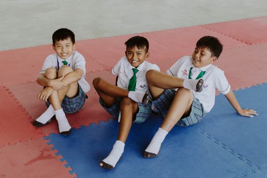 Portrait of Smiling Boys in School Uniforms Sitting on Floor