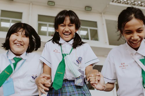 A Low Angle Shot of Young Girls in School Uniform while Holding Hands