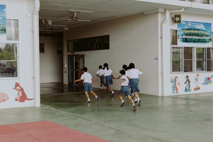 A Group Of Students Running Inside The School