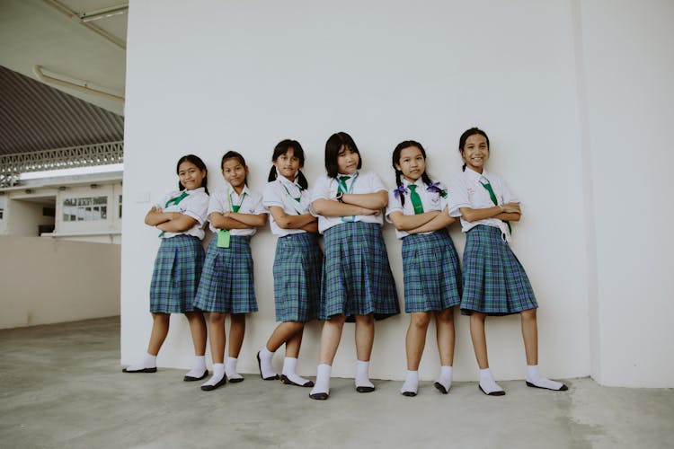 Portrait Of Girls In School Uniforms Standing In School Corridor