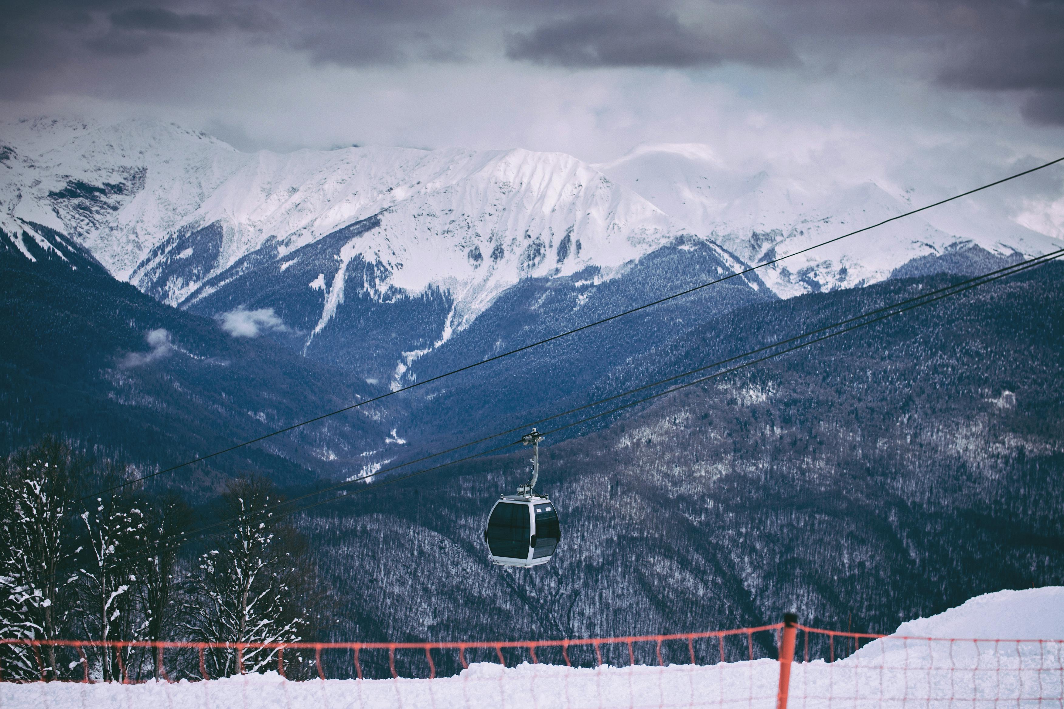 Prescription Goggle Inserts - Scenic view of snow-capped mountains with a cable car in a winter ski resort setting.