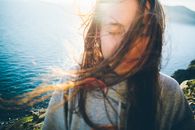 Teenage Girl with Windswept Hair and Closed Eyes by Sea