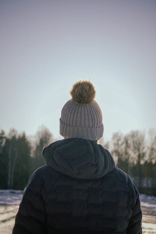 Free A Back View of a Person in Black Jacket and Knitted Cap Stock Photo