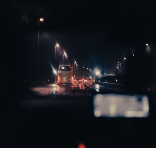 Free A nighttime highway scene featuring a bus and streetlights, evoking a sense of travel and city life. Stock Photo