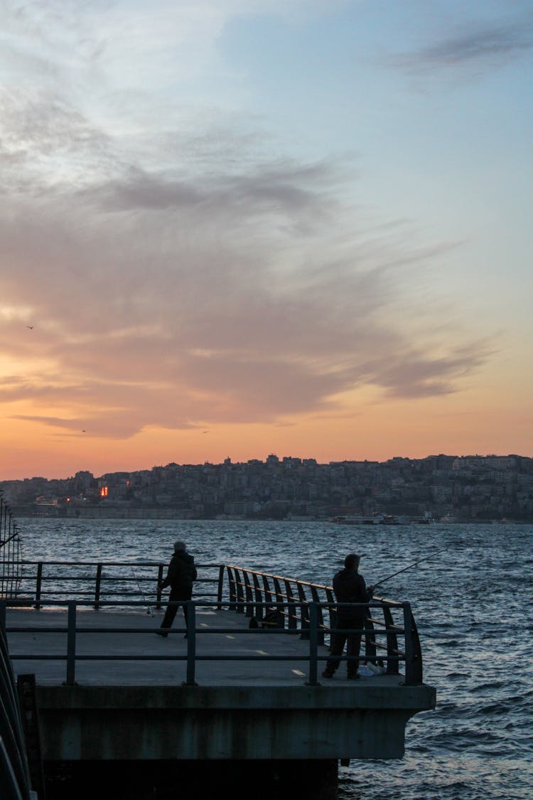 Man Fishing On The Dock During Sunset