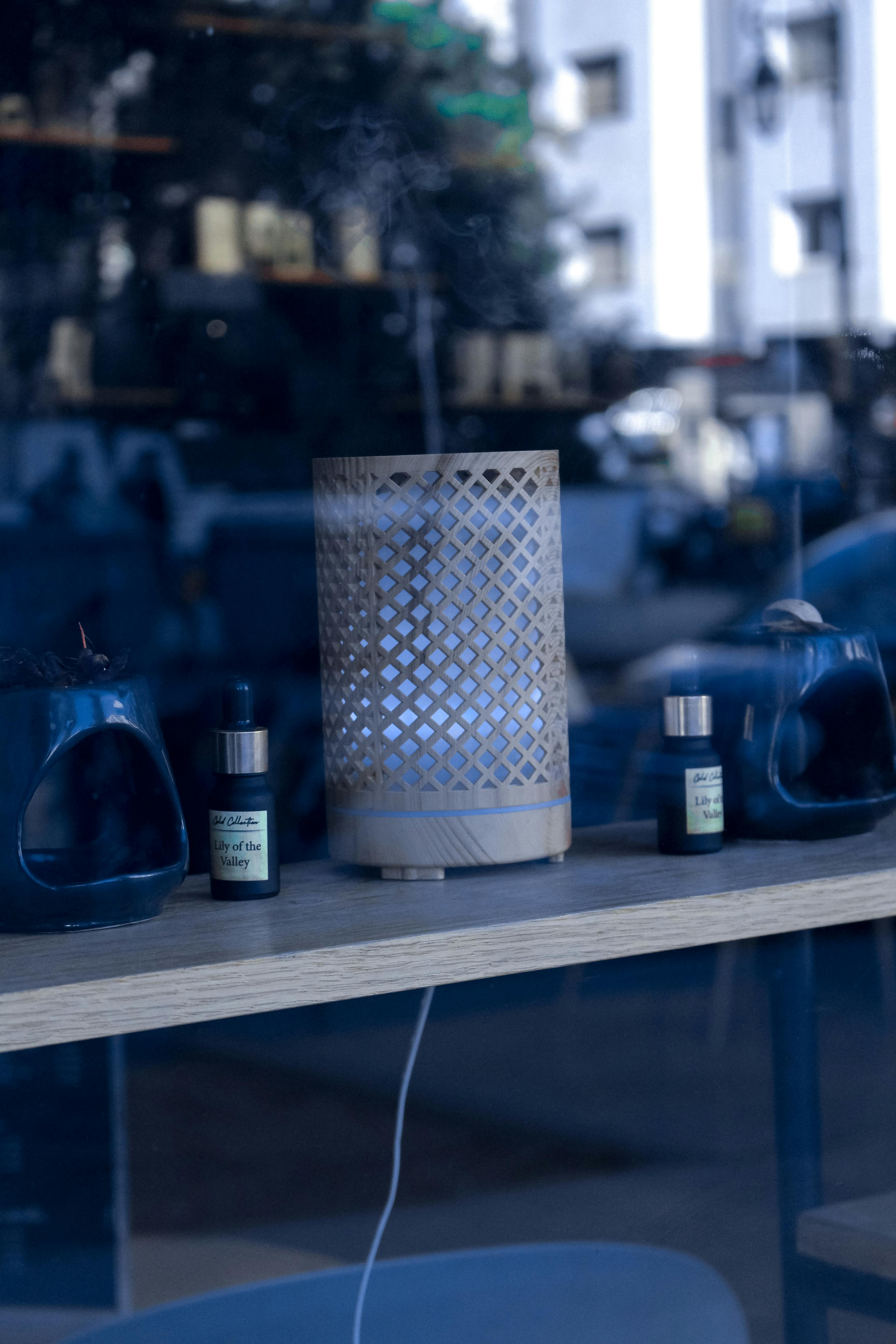 A wooden diffuser with essential oils on a shelf, captured in a modern indoor setting.
