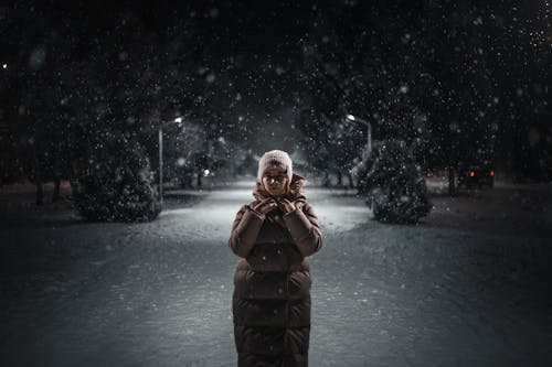 Shallow Focus of a Person in Brown Winter Clothes Standing on Snow-Covered Ground