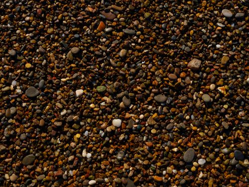 Free Detailed view of multicolored pebbles forming a textured surface on a beach. Stock Photo