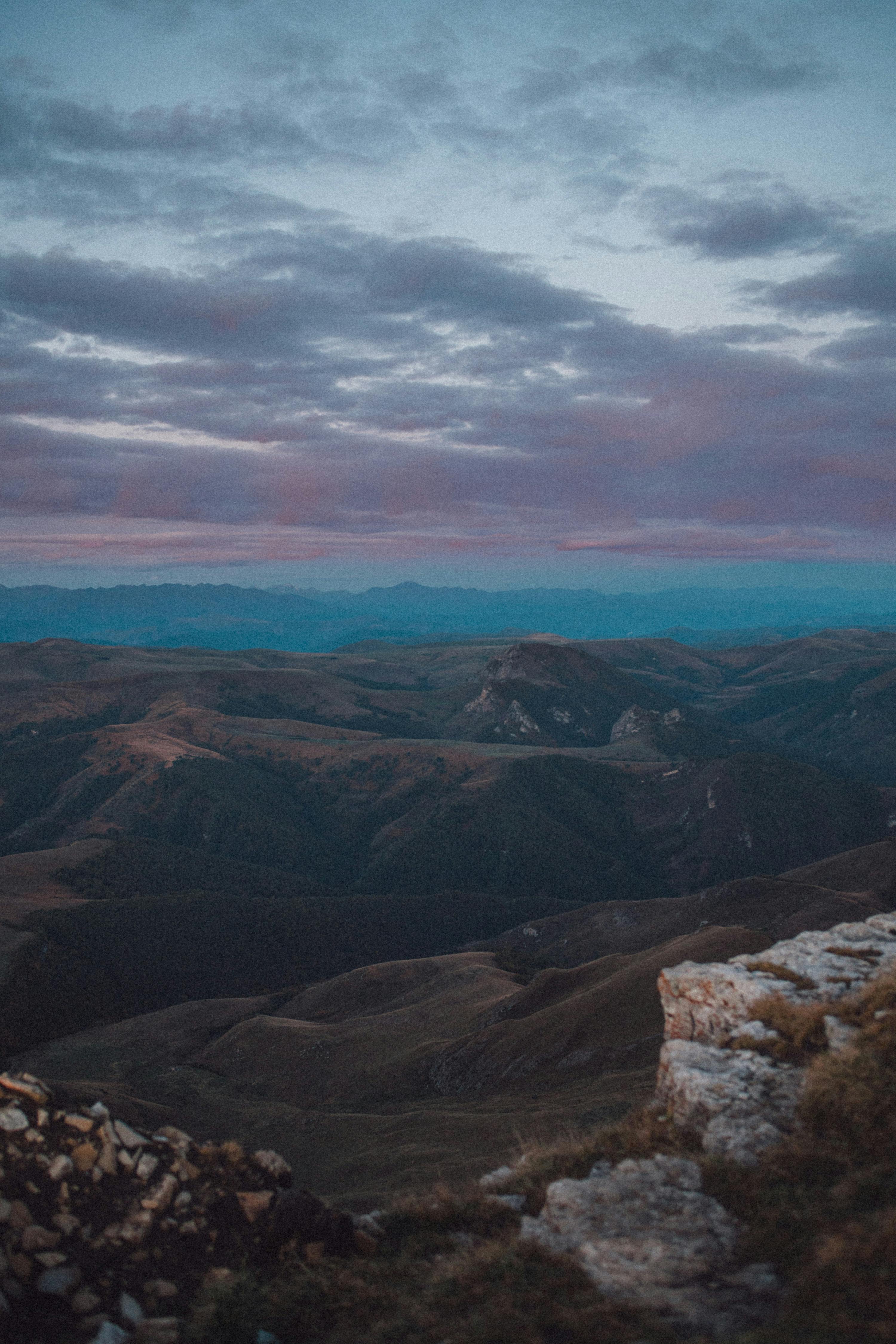 Stunning view of mountains under a dramatic sky, showcasing nature's beauty at sunset.