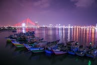 岘港海滨停靠着色彩缤纷的船只，夜间灯火通明的龙桥构成了令人惊叹的城市景观