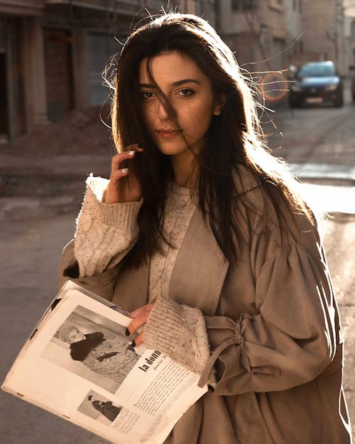 A Woman in Brown Coat Holding a Book