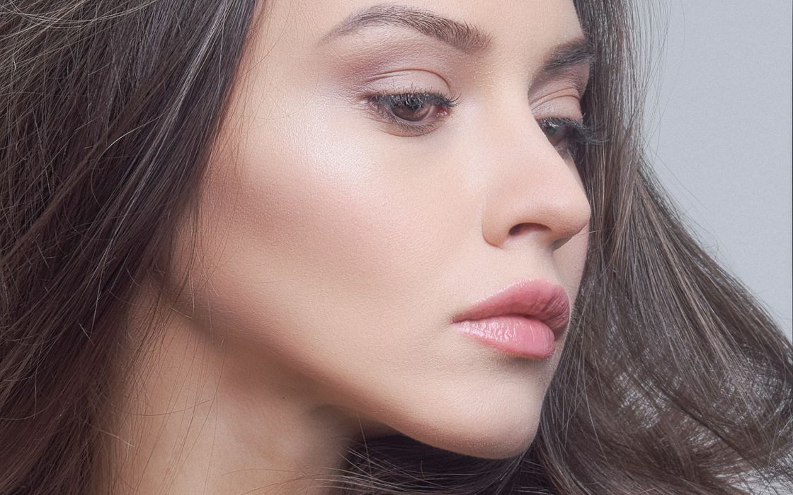Side profile of a young woman's face showing the cheekbone and the contour of the cheek