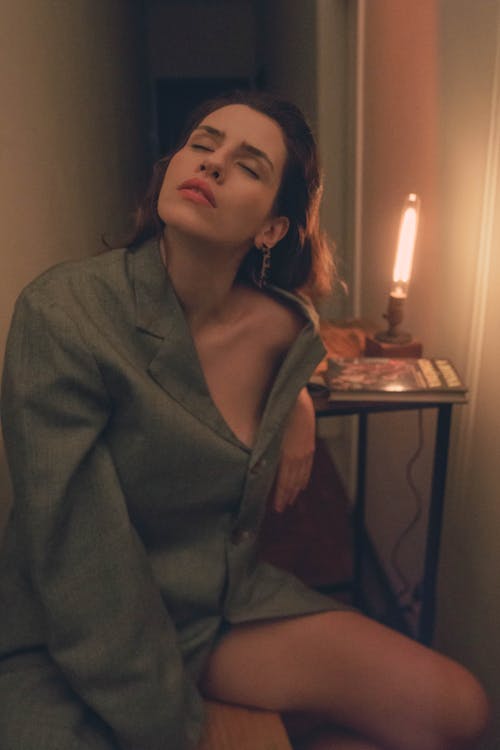 Seductive Woman Sitting on Chair Wearing Gray Blazer