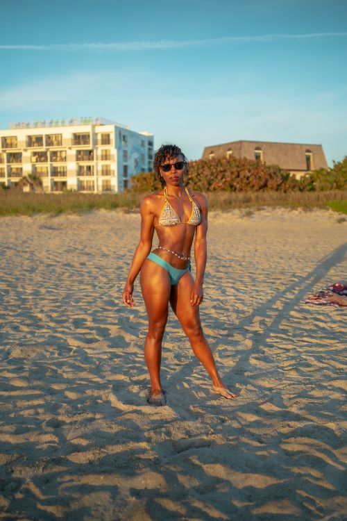 Free Stylish woman in swimwear posing confidently on Cocoa Beach, Florida. Stock Photo