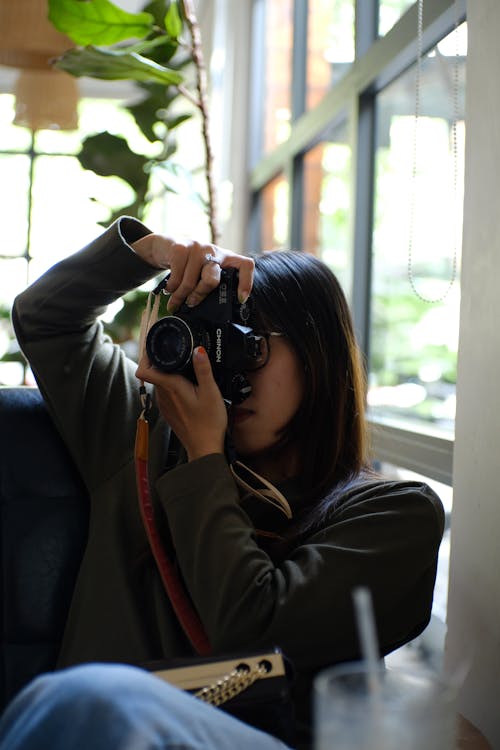 Free A Woman Taking Picture while Holding a Dslr Camera Stock Photo