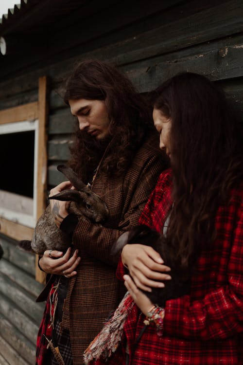 Couple Wearing Bohemian Clothes in Front of Wooden Barn