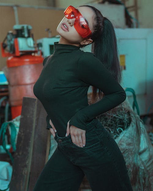 A Woman in Black Long Sleeve Shirt and Black Jeans Wearing Orange Sunglasses