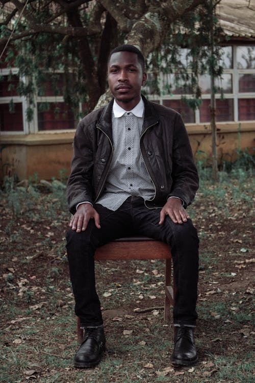 Free Man in Black Leather Jacket Sitting on Brown Wooden Chair Stock Photo