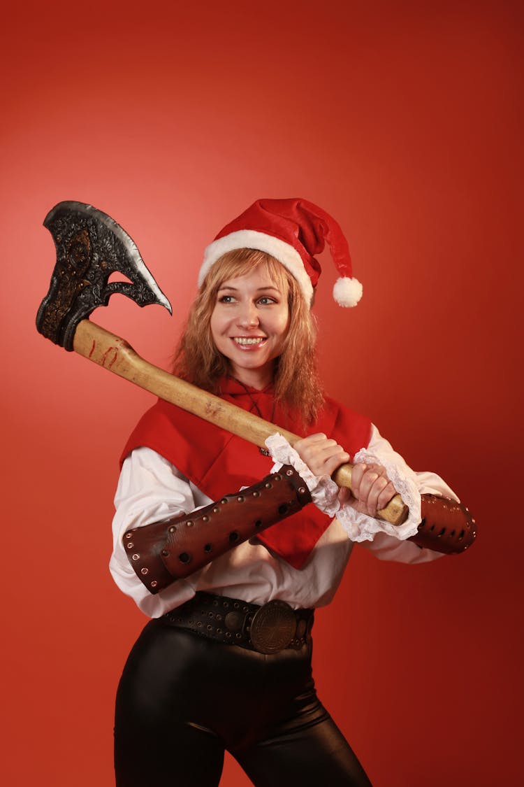 Woman Wearing A Santa Hat Holding Axe