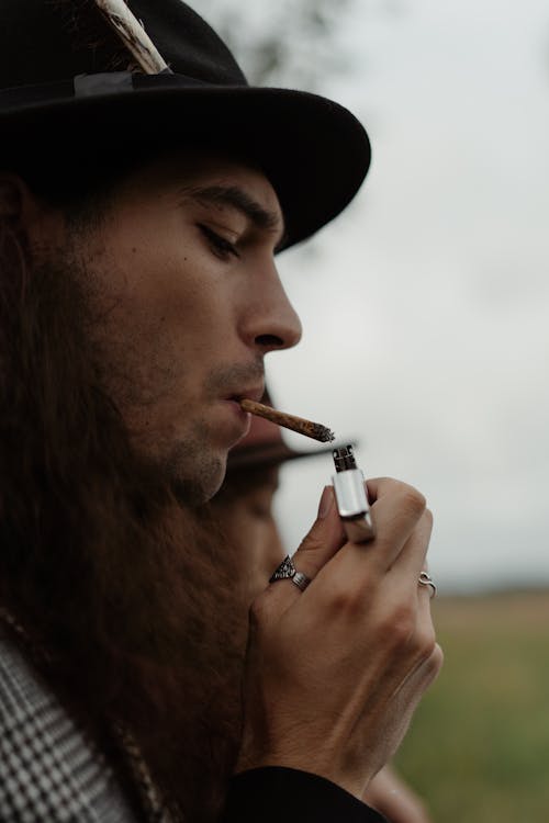 Free Man Lighting Cigarette with Zippo Lighter Stock Photo