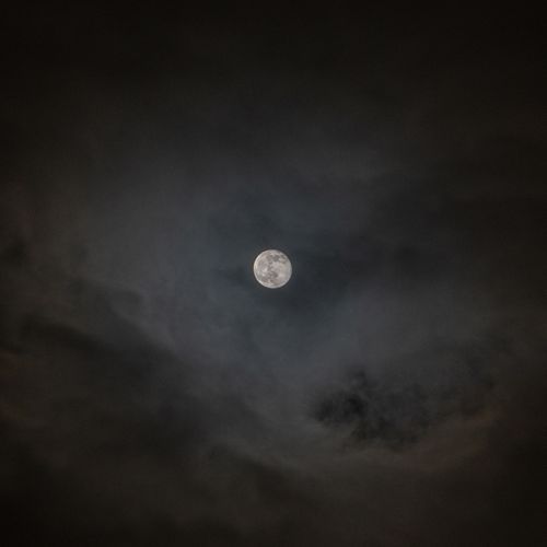 Free A mesmerizing view of the full moon enveloped by dark stormy clouds. Stock Photo
