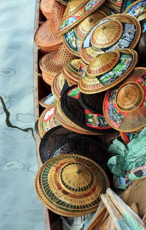 Free Colorful traditional straw hats stacked in a wooden boat at Khlong Hae Floating Market, Thailand. Stock Photo